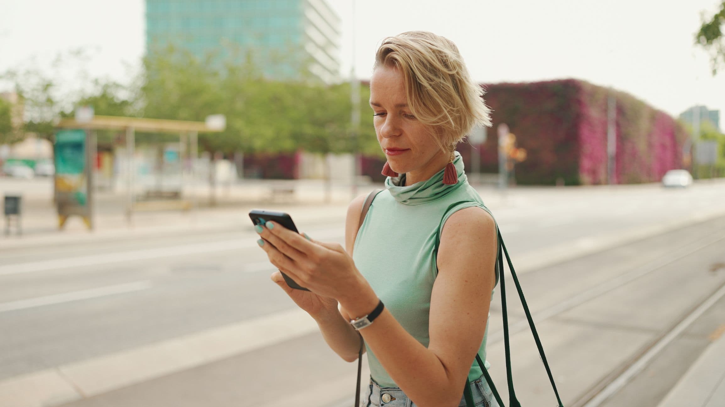a woman is smiling while looking at her phone