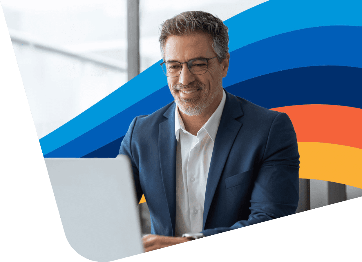 a man in a suit is smiling while using a laptop