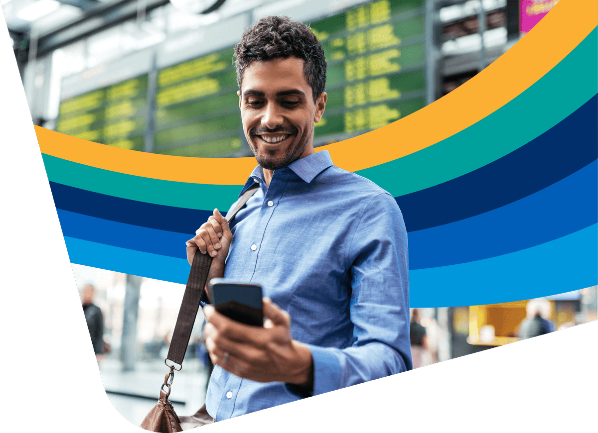 a man is smiling while looking at his cell phone