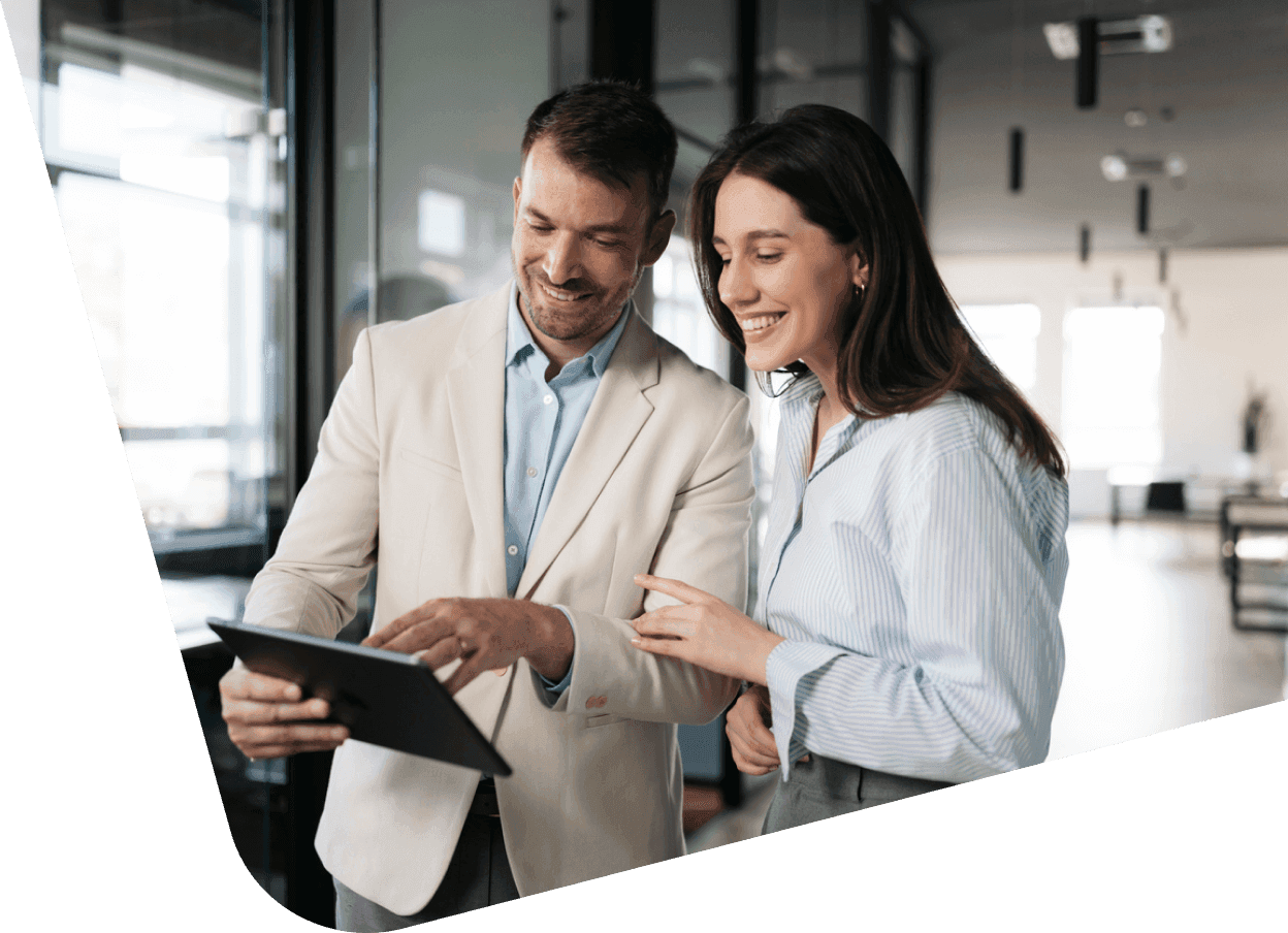 a man and a woman are looking at a tablet together
